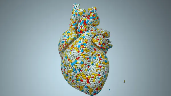 3D render using close-up of heart model covered with white, red, yellow pills