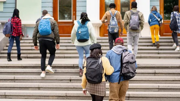 College students climb up the stairs to a campus building.