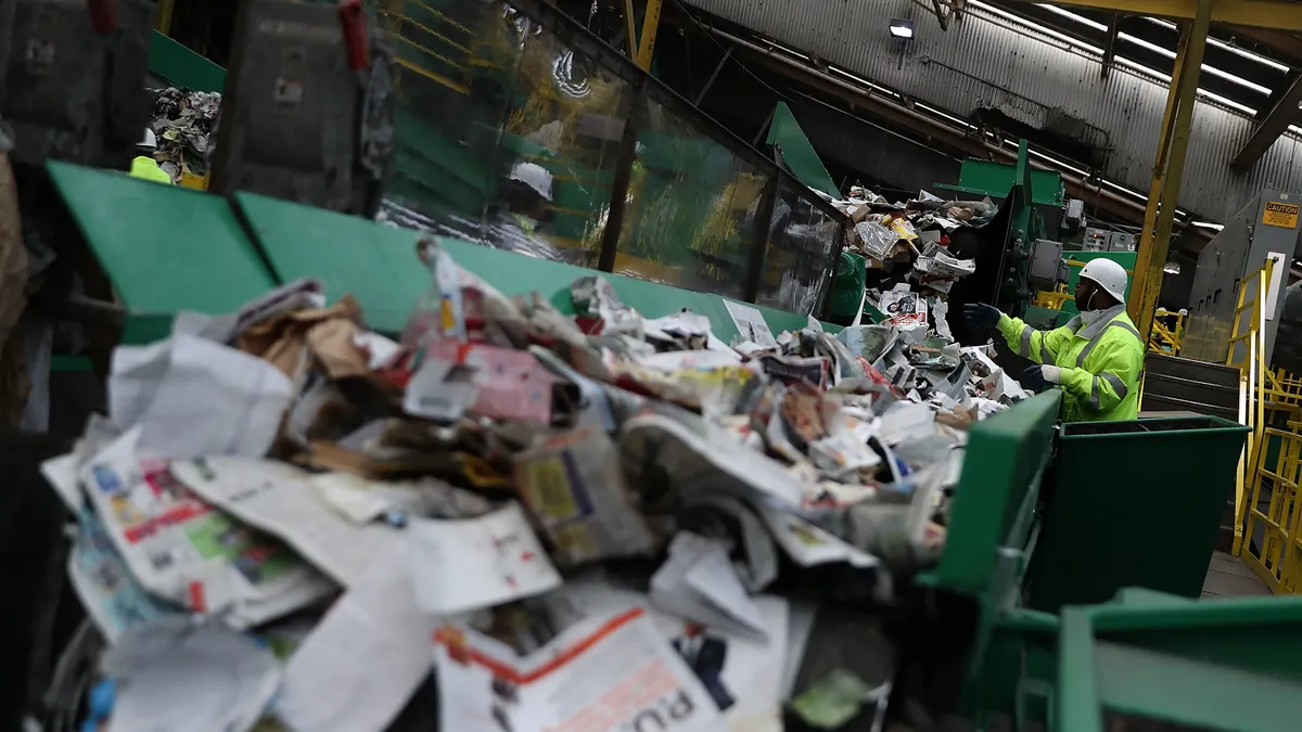 Workers sort recyclables on a conveyor.