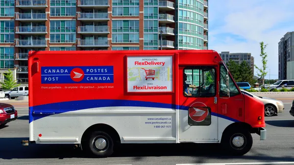 A Canada Post delivery truck on the road.