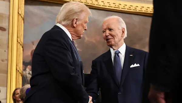 Two men in suits shake hands