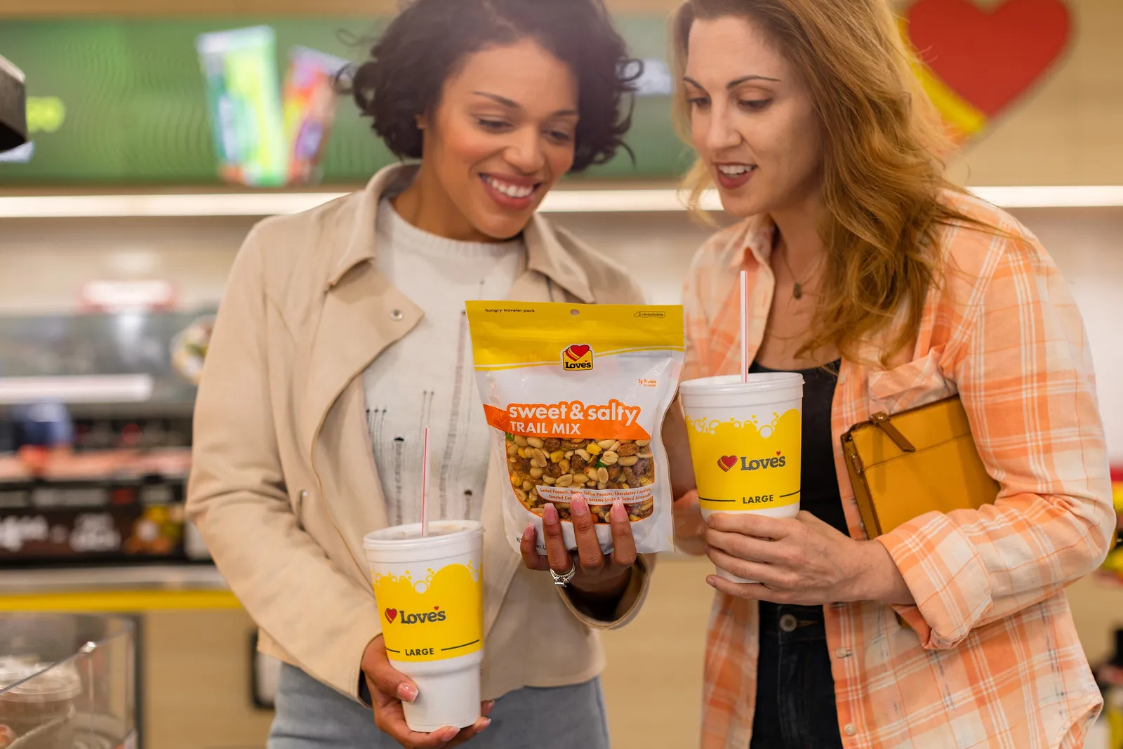 A photo of two people holding Love's store branded items, including trail mix.