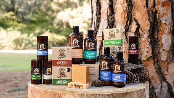 An array of Dr. Squatch men's body and skincare products displayed in a forest setting.