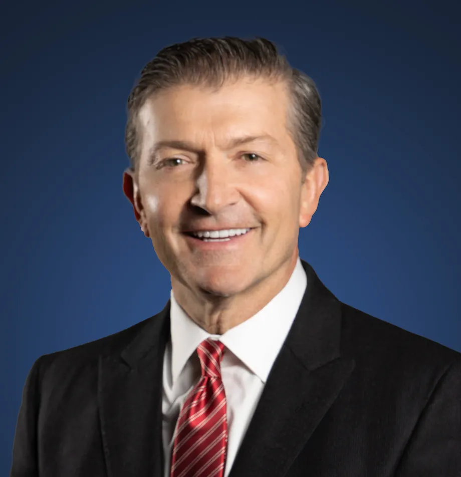 A headshot shows a man wearing a business suit.