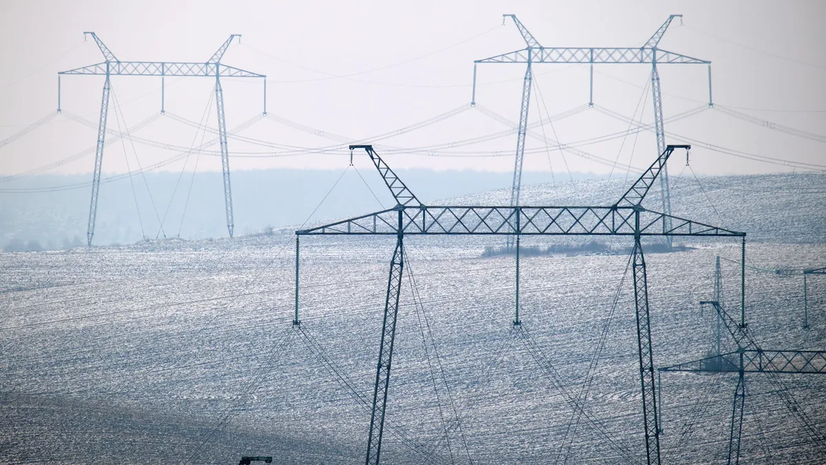 Electric power lines running across a hilly landscape.