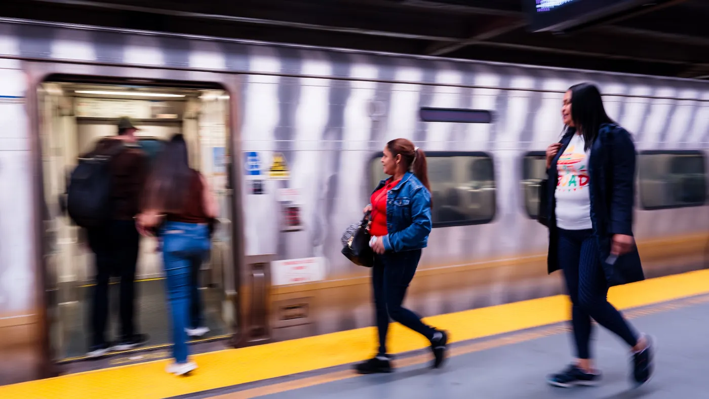 An action image of people boarding a train from a platform.