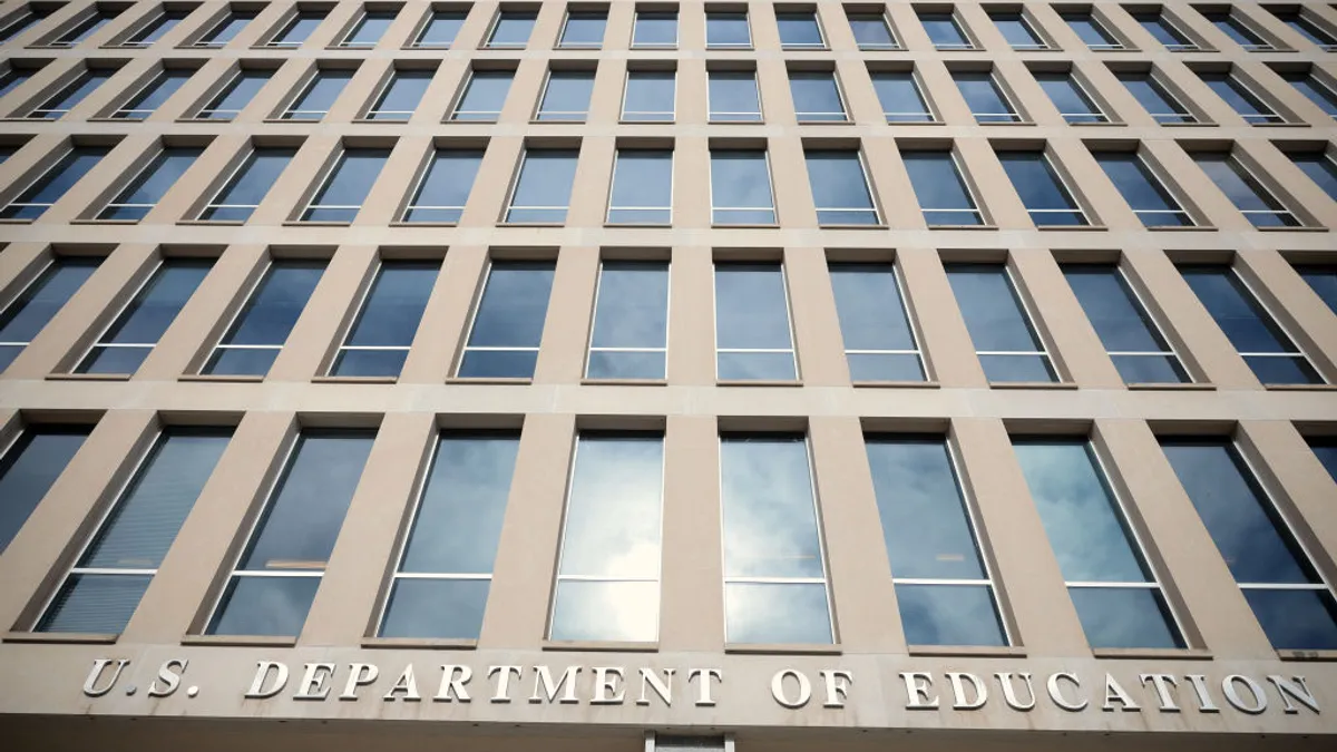 The side of a building with white stone and windows is shown. Letters on the building read: U.S. Department of Education