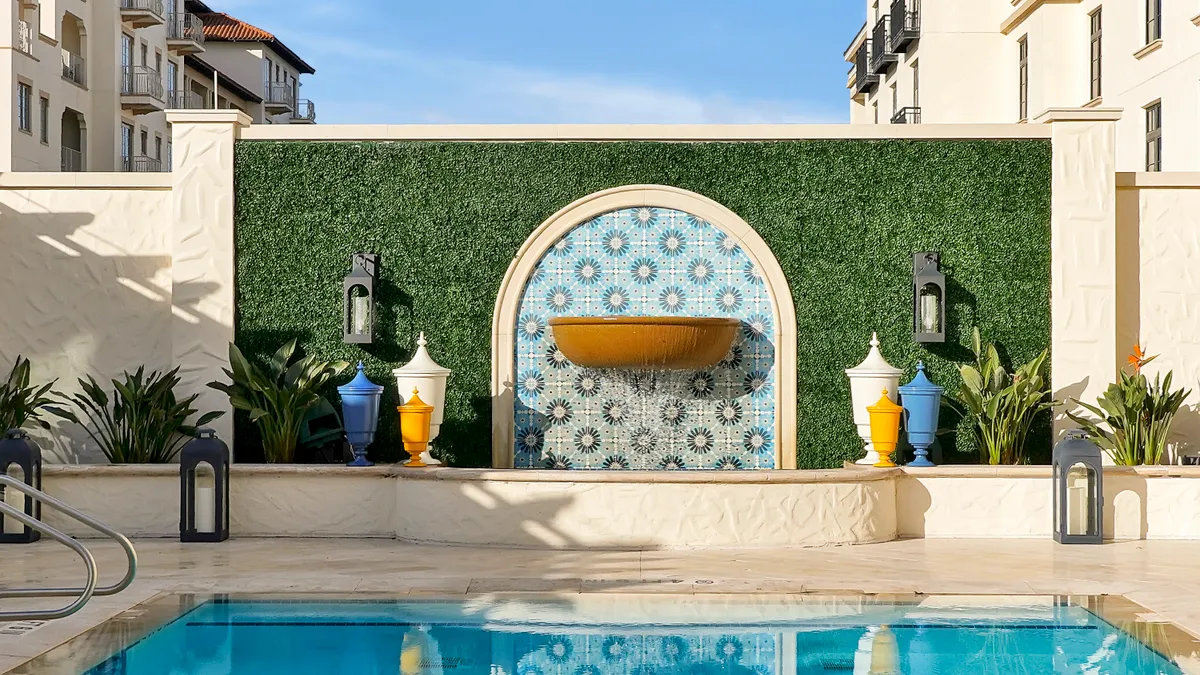 A fountain is seen next to a pool.