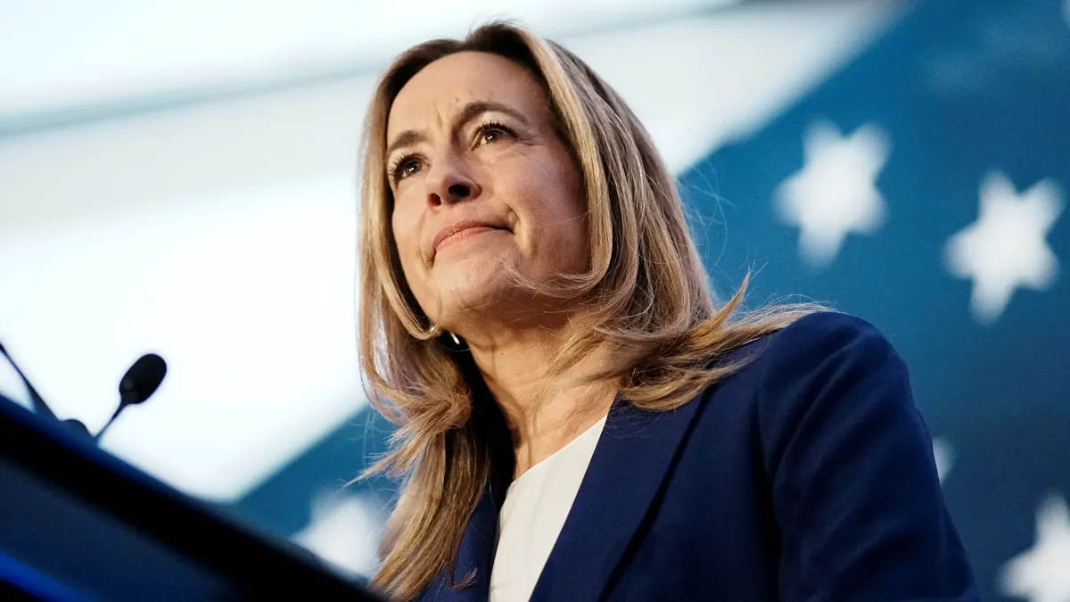 A woman stands at a podium.