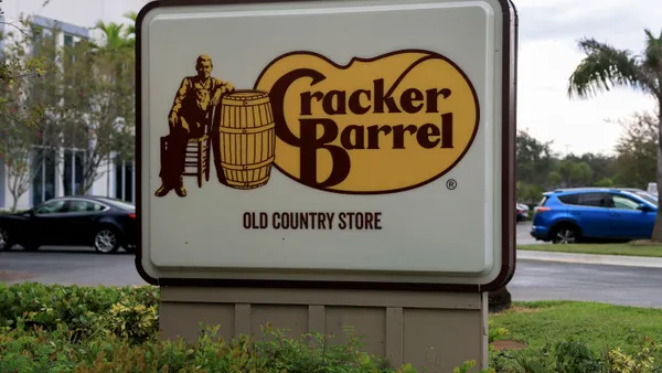 A close up imae of a white sign with Cracker Barrel logo and Uncle Herschal mascot.