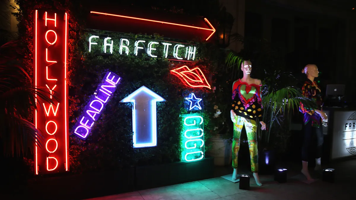 Neon signs and mannequins on display at an evening event for the company Farfetch.