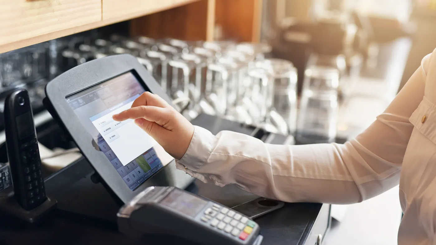 Person using a point of sale software system at a restaurant