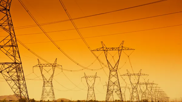 Electrical power grid and power line towers at sunset.