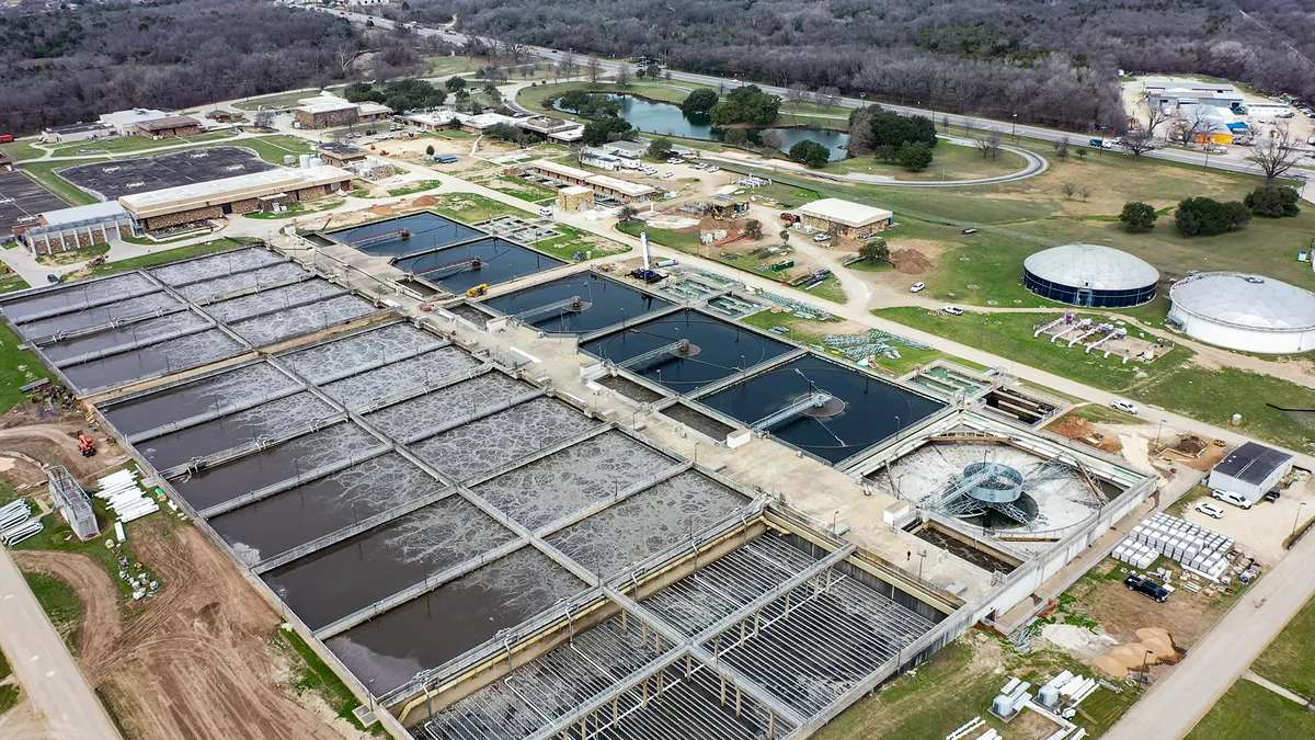 Aerial view of massive vats of water, being cleaned by large equipment.