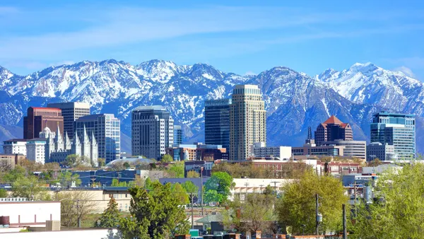 Tall office buildings with snowy mountains in the background.