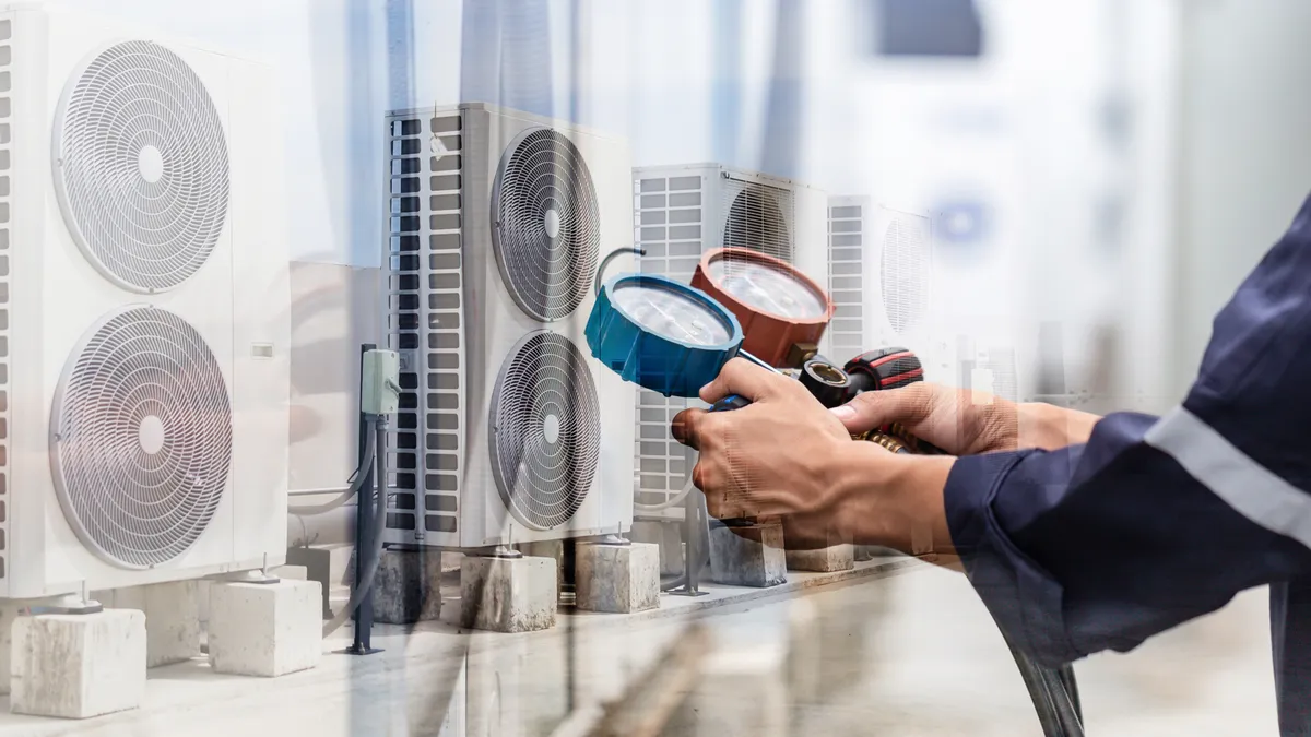 A technician checks and measures air conditioner equipment.