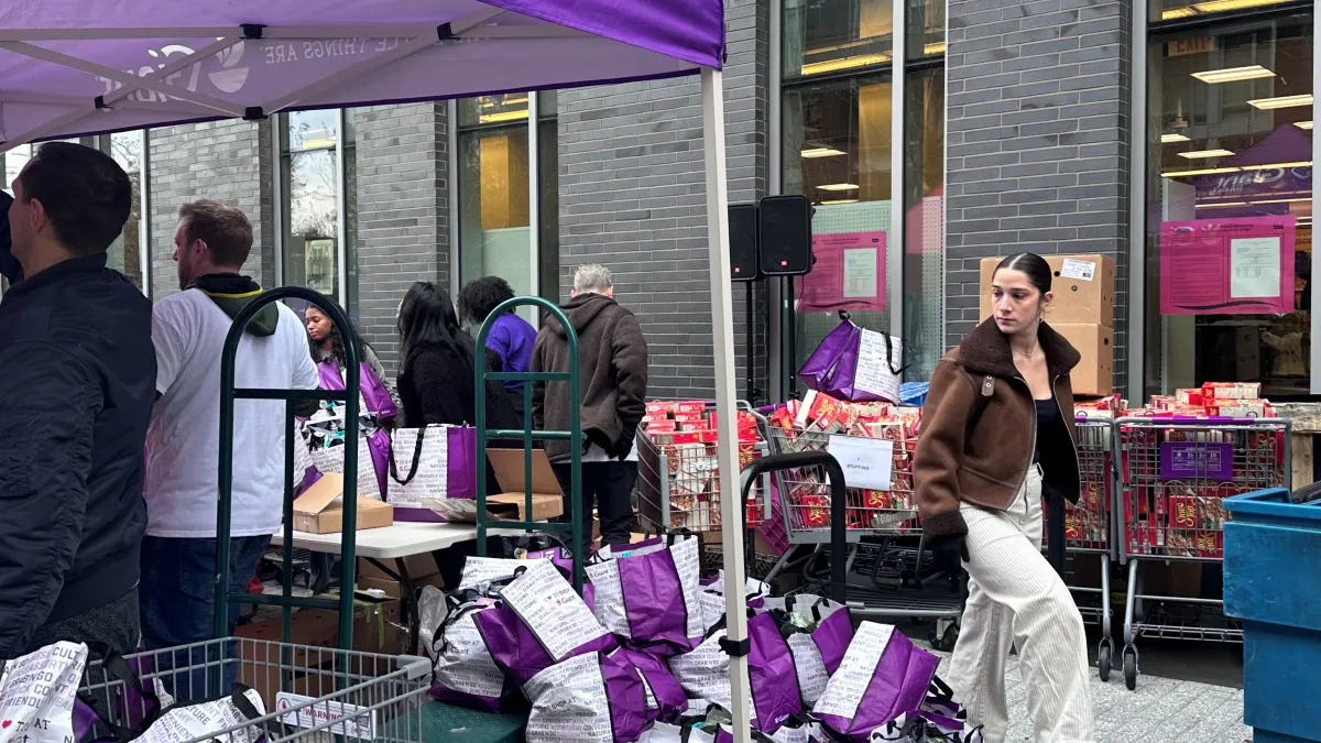 Group of individuals giving away food in front of a Giant Food location ahead of Thanksgiving