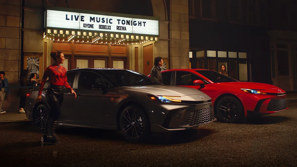 Two Toyota Camry cars in front of a music venue in a new ad