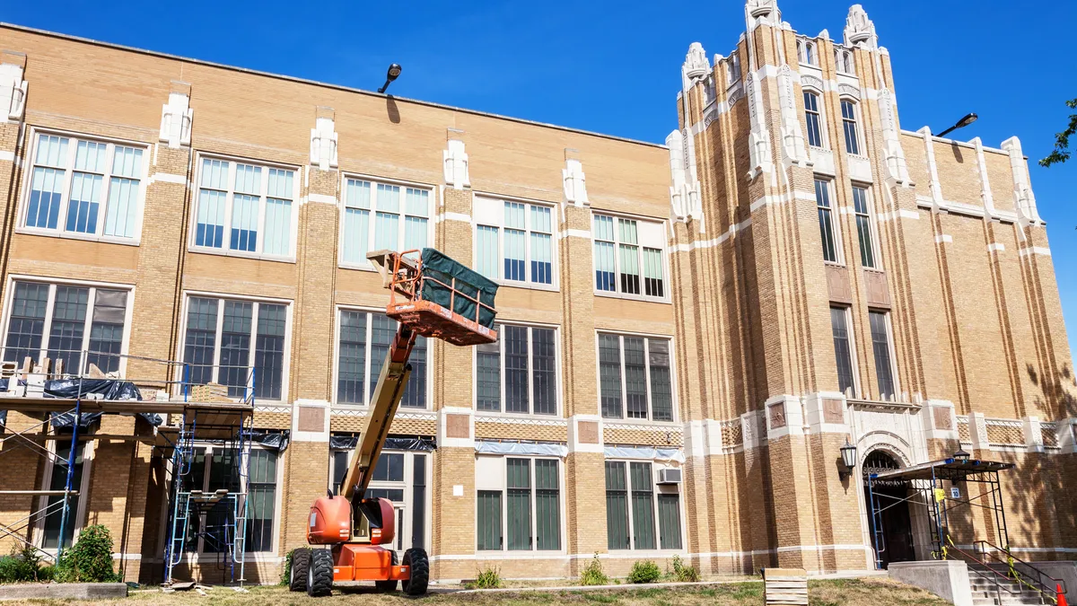 A the exterior of a school in Washington Heights, Chicago is being renovated by a construction team.