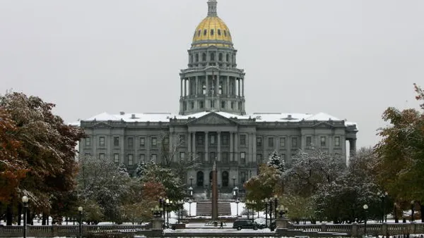 Colorado State Capitol Building stands across a snow covered Civic Center Park