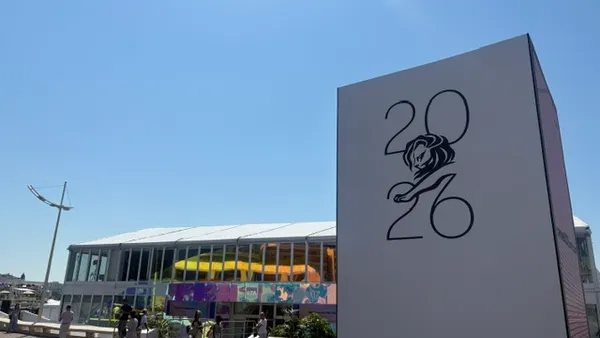 A sign for Cannes Lions stands on a beach promenade in Cannes, France