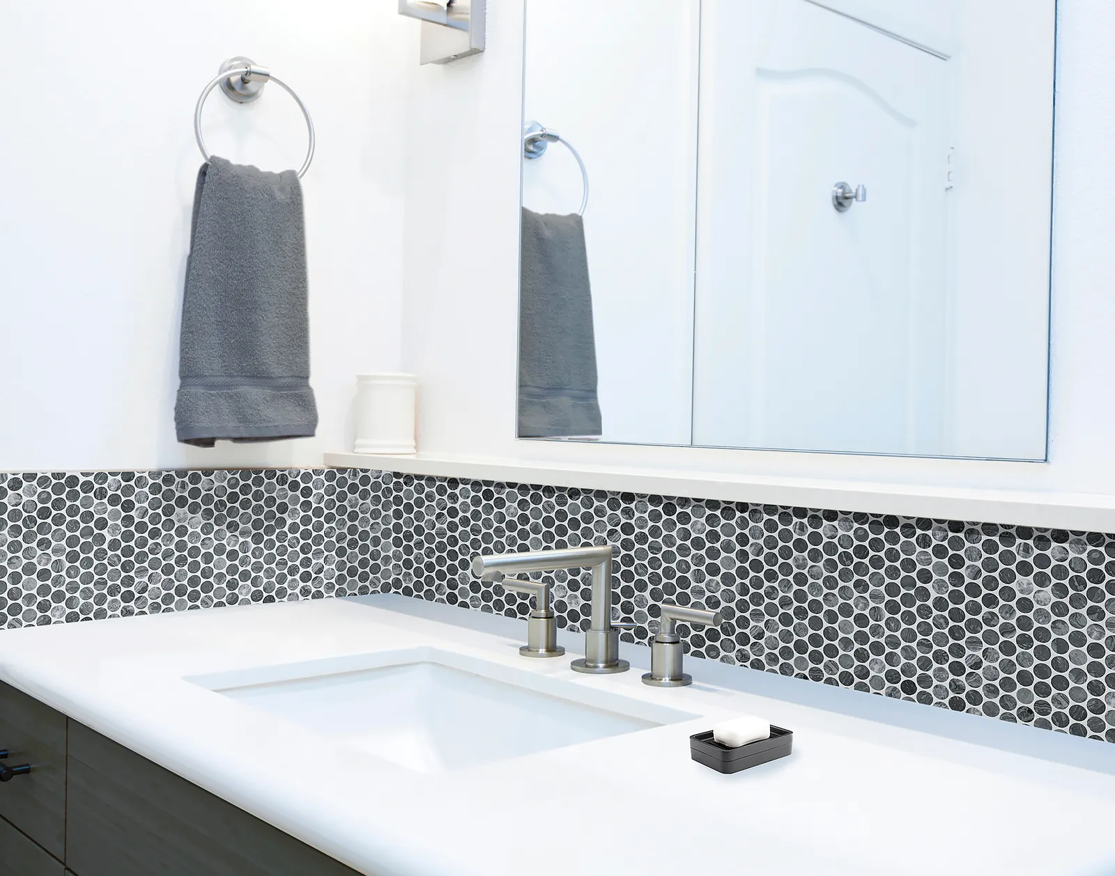 A bathroom with a round, black tile backsplash.