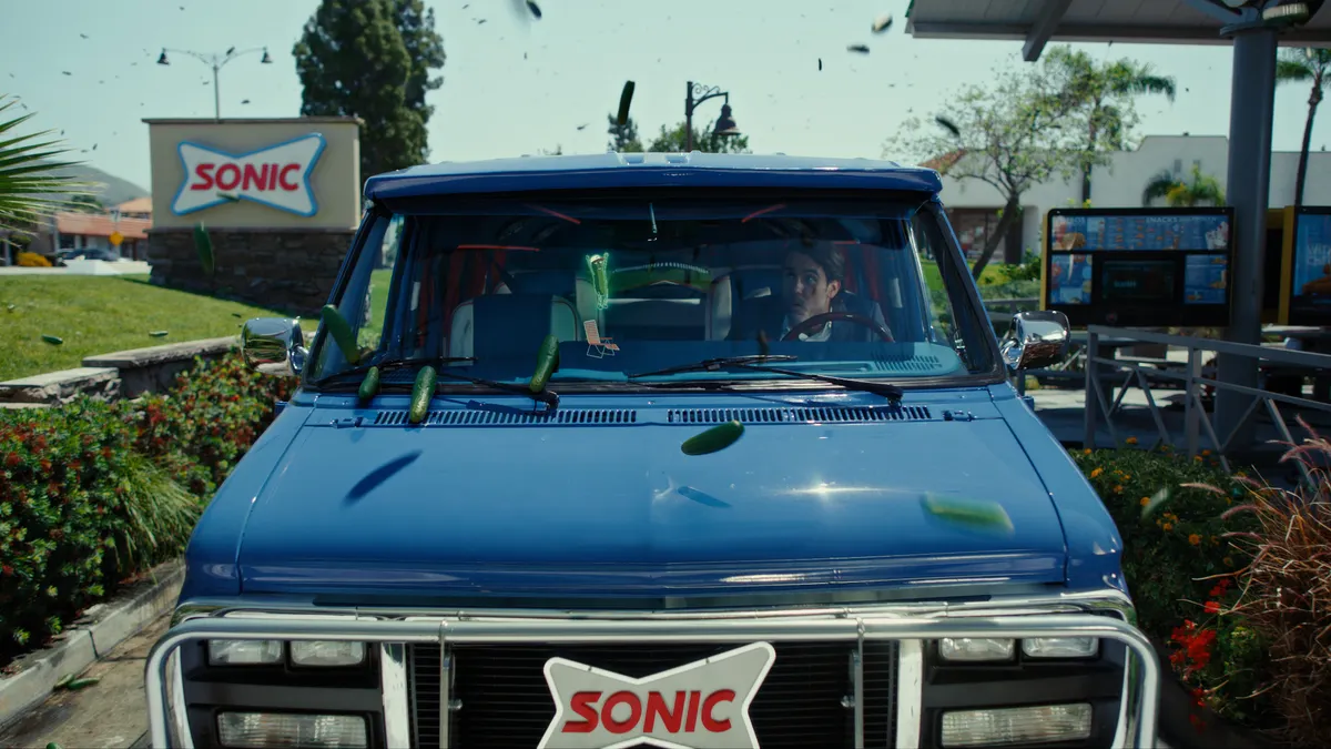 Pickles rain down on the top of a car in an ad from Sonic Drive-In