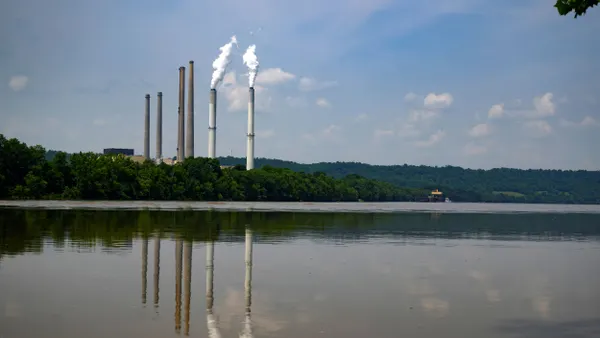 Stacks from a power plant seen next to a river.