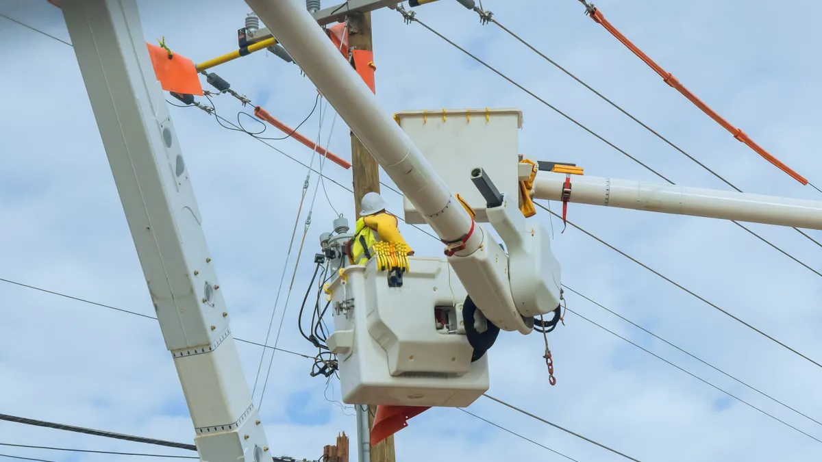 Utility service men repair power lines.