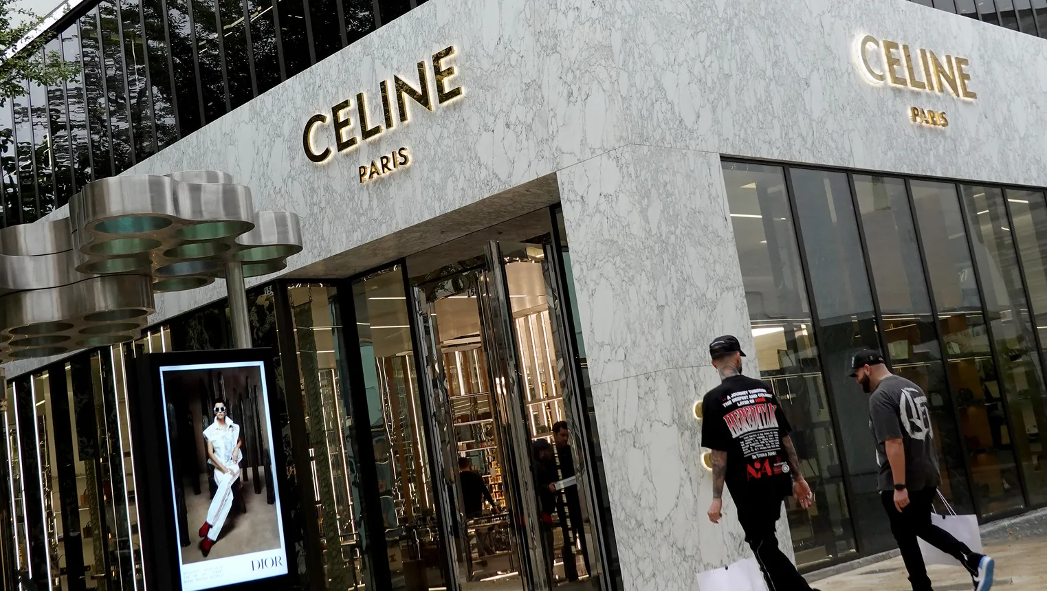 Shoppers walk past a Celine store.