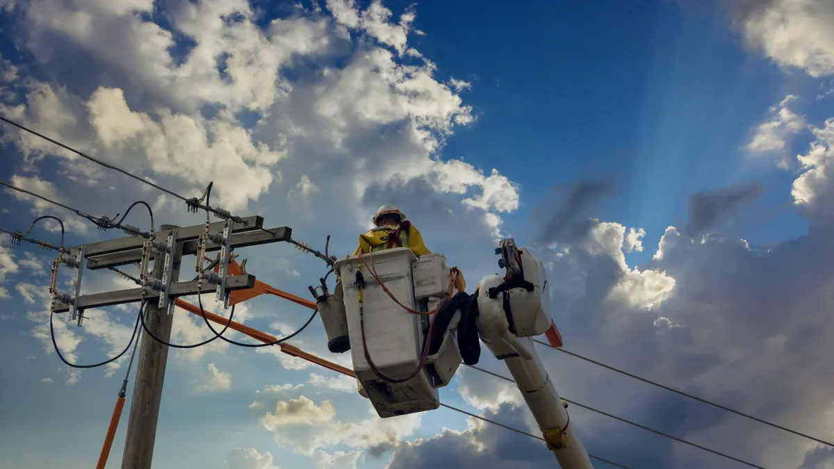 A utility worker checks a power line after a tornado.