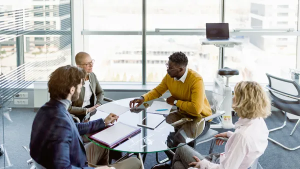 People signing contracts in a meeting