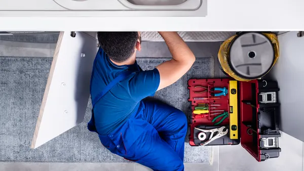 Plumber working under a sink