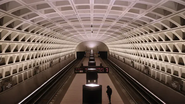 A single rider waits on a train platform at a Washington Metro rail station.