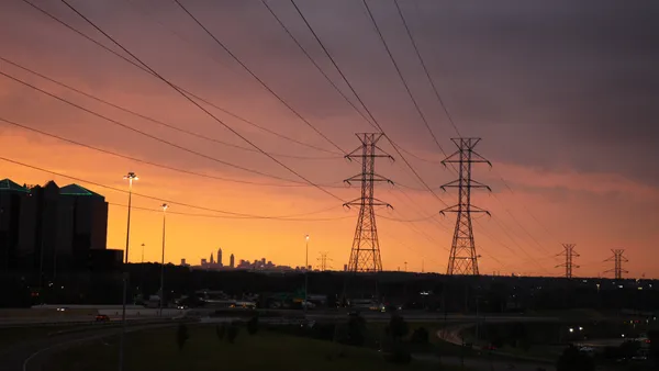 Power lines leading into the city of Cleveland Ohio at sunset time.