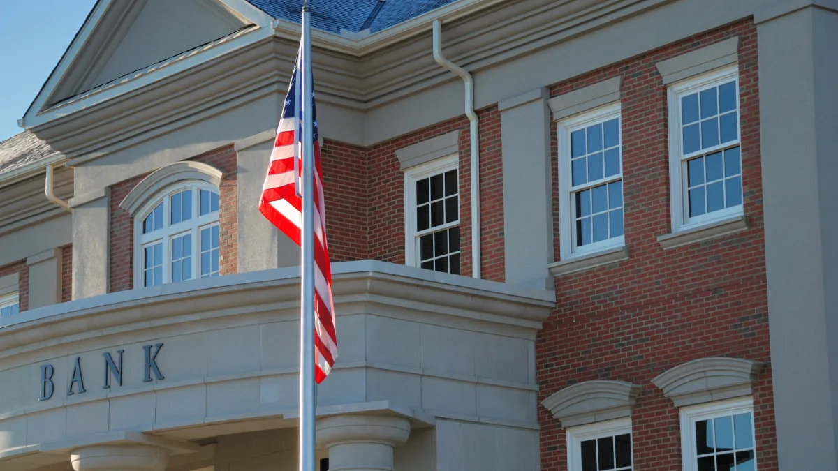 American bank building is pictured with an American flag flag on cold morning.