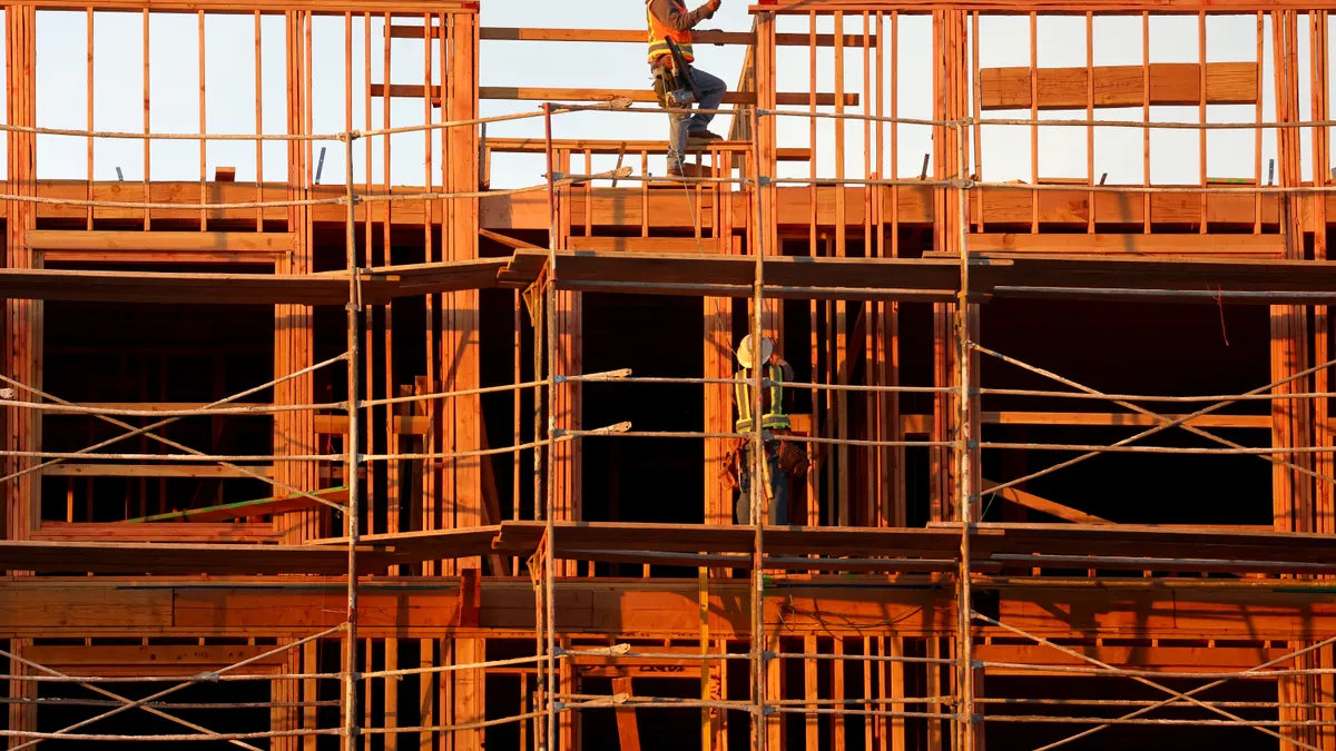 A photo shows construction workers building a structure.