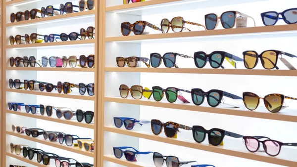 A variety of sunglasses are displayed against a lighted background.