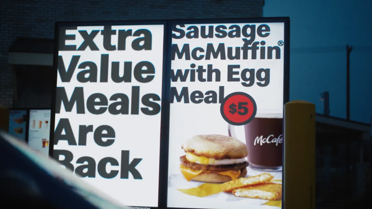 An image of a digital menu board that says "Extra Value Meals are back" on the other panel there is a photo of an egg sandwich and a $5.
