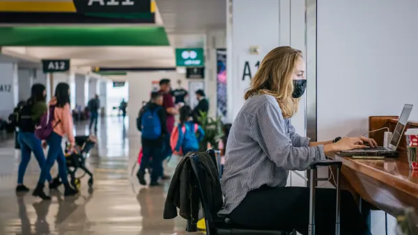 A person working on a laptop in an airport.