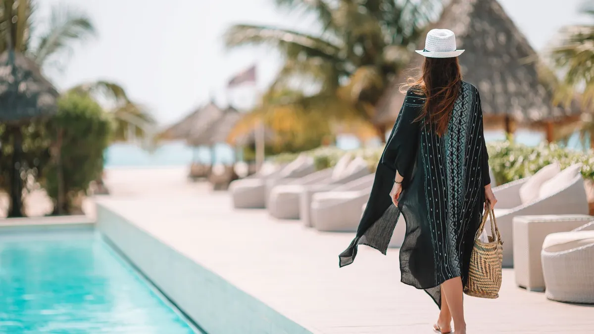 Woman relaxing by the pool in a luxury hotel resort enjoying perfect beach holiday vacation
