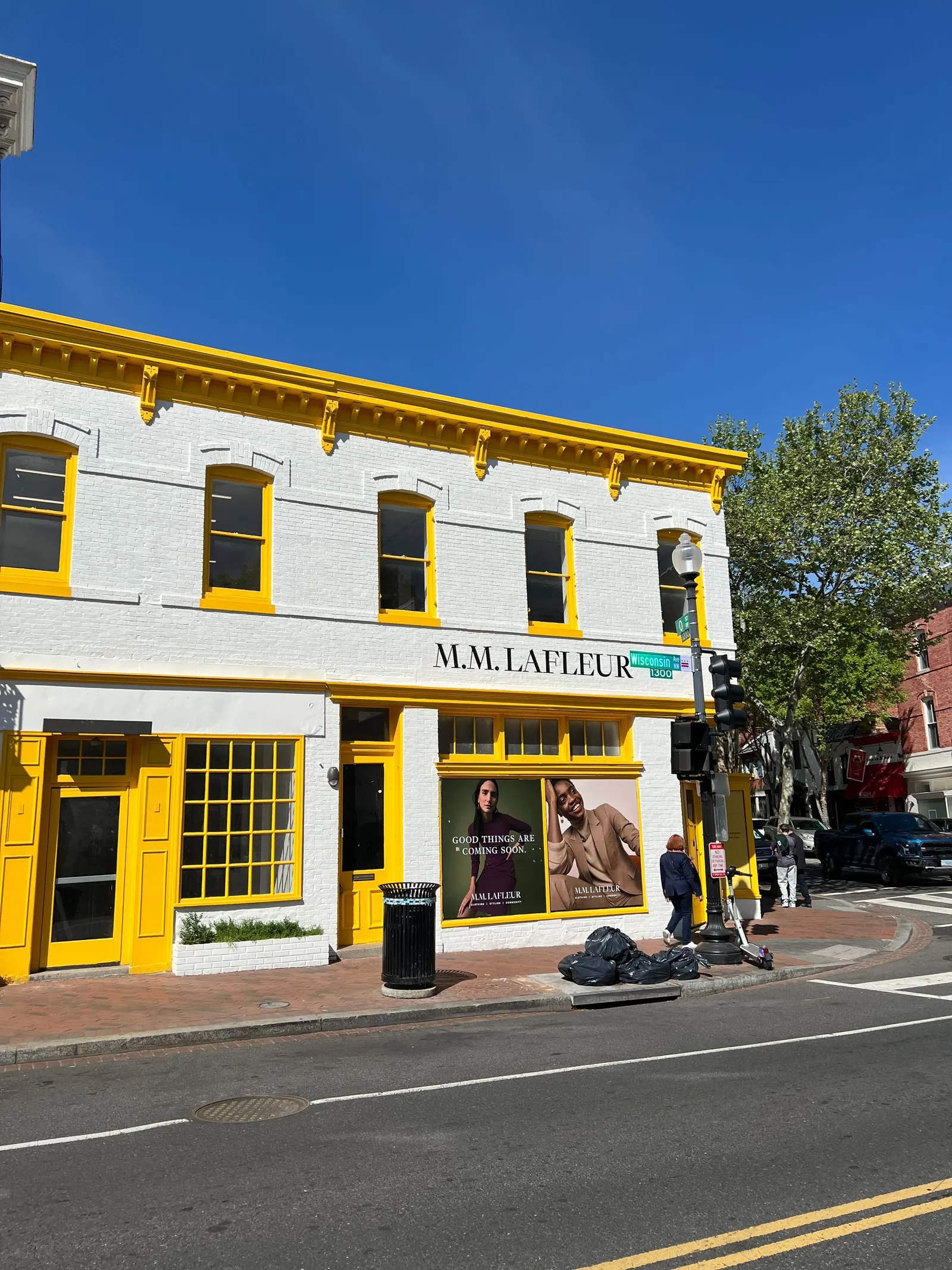 A white store with yellow trim, with the words &quot;M.M. LaFleur&quot; painted in black.