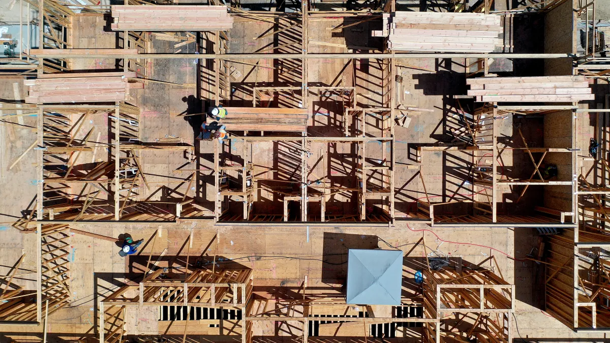 Aerial shot of wooden beams put together in the early stages of housing construction.