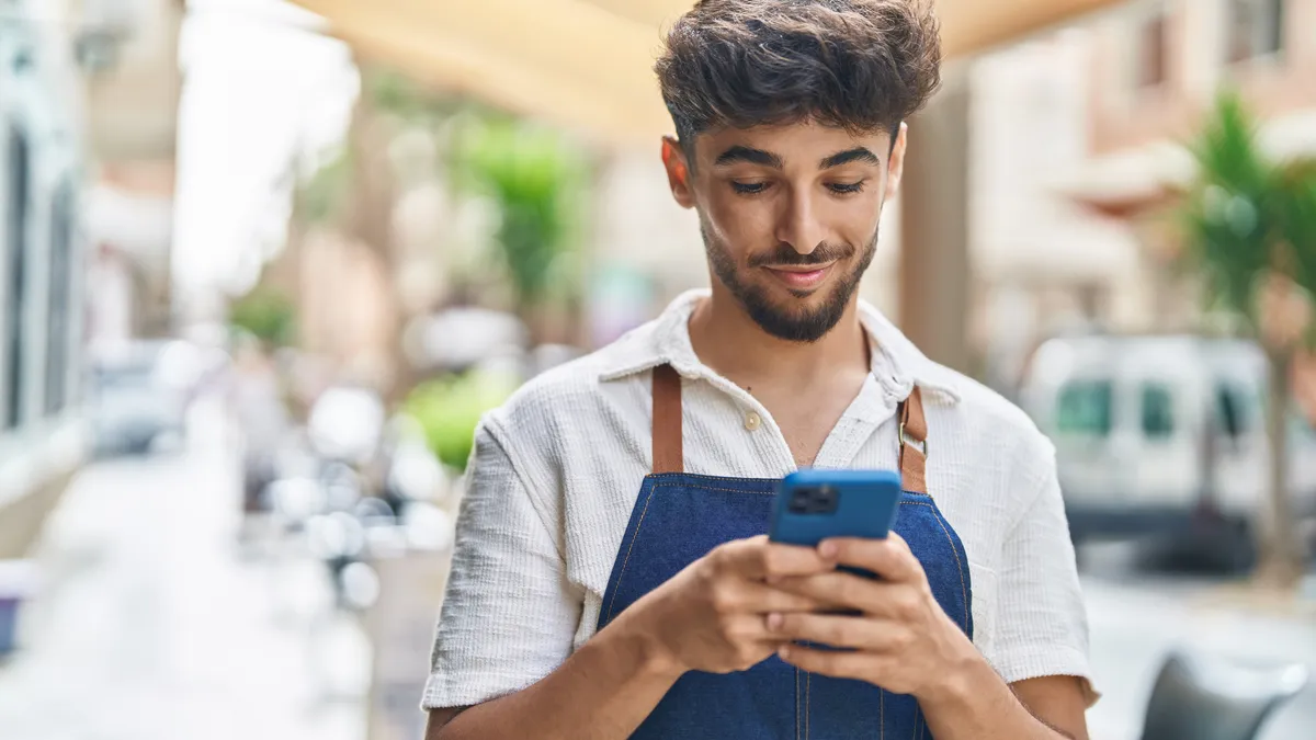 Person in apron looking at phone