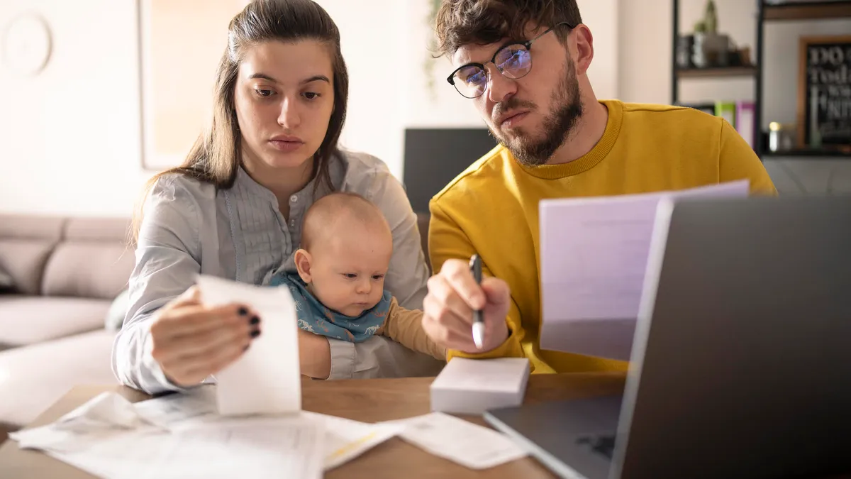 Young family with small baby calculating monthly expenses