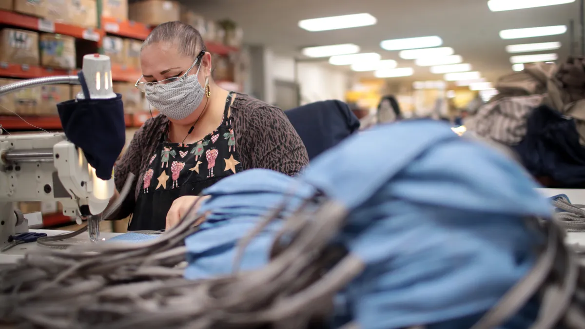 A woman with a sewing machine is making Covid masks