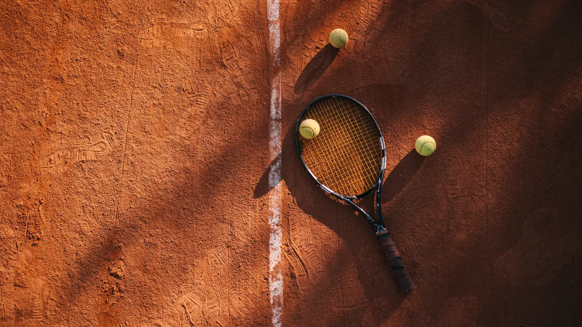 High angle view of a tennis racket on a clay court near baseline