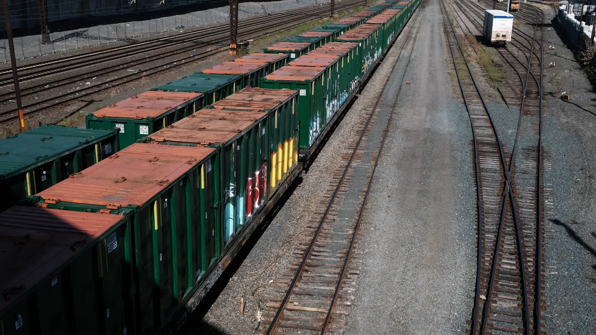 Green train cars sit on rail tracks