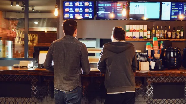 Two people ordering food at a counter