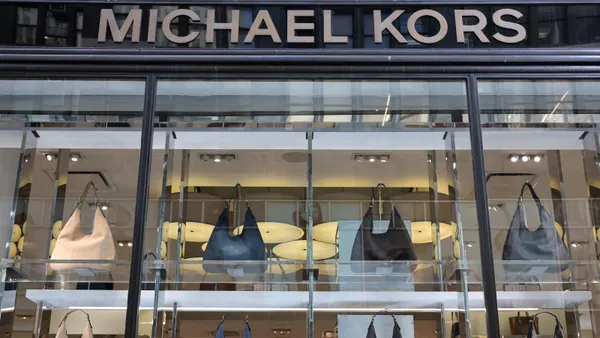 The storefront of a Michael Kors shop shows severa;